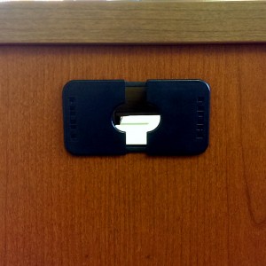 Hole on the front of jeans desk showing pieces of paper that have been shoved inside